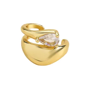Detailed macro view of a gold-plated twisted ear cuff featuring a teardrop zircon