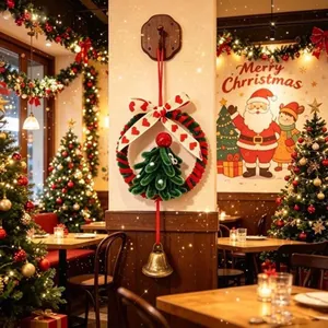Ghirlanda di Natale fatta a mano con albero verde, nastro a cuori e campanello nel caffè