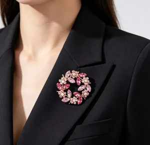 Macro detail of elegant pink crystal wreath brooch on a black blazer