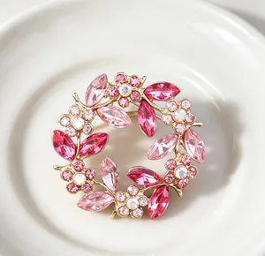 Macro detail of a vintage gold wreath brooch with pink crystal floral elements