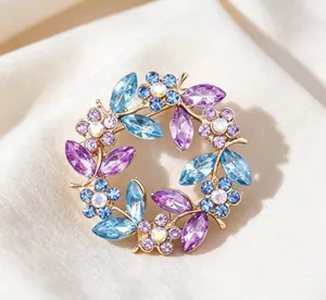 Close-up of a vintage crystal wreath brooch with blue and purple floral rhinestones