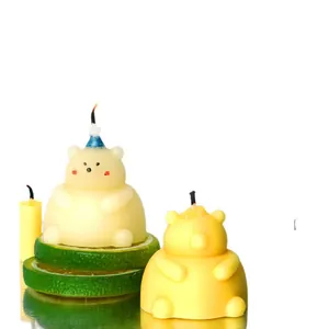 Handmade 3D chubby bear shaped scented candles in cream and yellow on lime slices