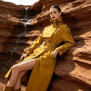 Detailed view of a mustard yellow belted trench coat in a desert rock setting