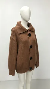 Close-up detail of oversized brown knitted cardigan featuring large black buttons.