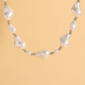 Macro detail of baroque style irregular pearl necklace with metallic silver bead accents
