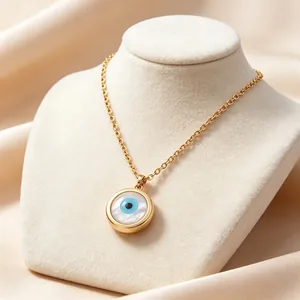 Vista macro di una collana con malocchio placcata oro e intarsio in madreperla su espositore