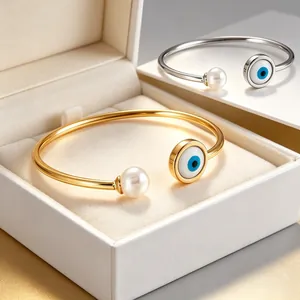 Vista dettagliata di bracciali con occhio di Allah dorati e argentati con perle