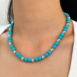 Detailed view of bohemian turquoise and silver beaded necklace worn on model neck