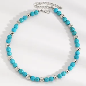 Detail view of a Bohemian turquoise and silver beaded necklace on a white background.