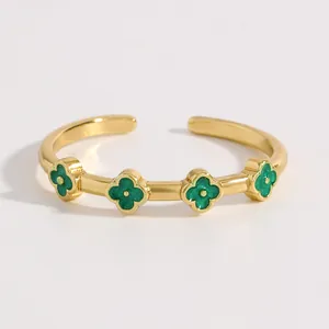 Dettaglio di un anello in acciaio dorato con quattro motivi a quadrifoglio verde