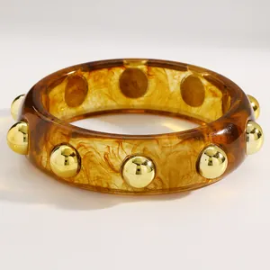 Vintage amber acrylic wide bangle with polished gold stud accents close-up detail