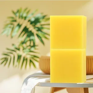 Gros plan de deux savons artisanaux rectangulaires au citron et au curcuma empilés