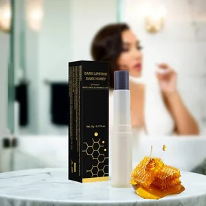 Rossetto idratante Dark Honey con confezione e favo di miele su piano in marmo.