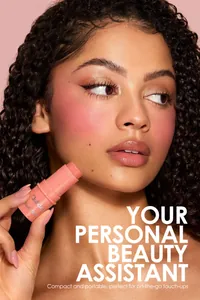 Model applying a peach cream blush stick for a natural matte finish on her cheeks