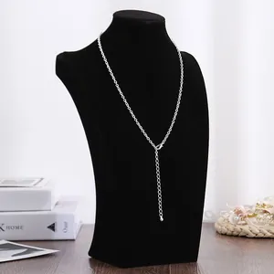 Detailweergave van een elegante zwarte fluwelen ketting display buste op een tafel
