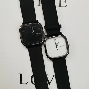 Primo piano di orologi al quarzo minimalisti bianchi e neri con cinturini in silicone