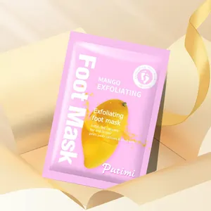 Detail shot of mango exfoliating foot mask packet inside a gift box with ribbon.