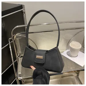 Retro black baguette shoulder bag with matte finish and metal buckle detail.