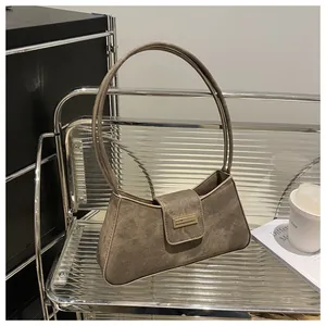 Vintage mocha underarm baguette bag with single strap displayed on a modern acrylic chair