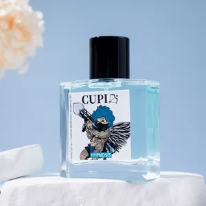Detailed view of CUPI Hypnosis blue eau de parfum bottle on an elegant white stone pedestal