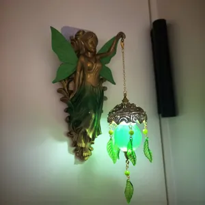 Exquisite bronze fairy wall lamp detail with a glowing green lantern for magical home decor style