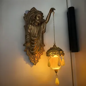 Detailed view of vintage gold Jesus sculpture wall lamp with glowing lantern.