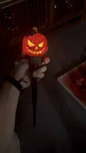 Detailed macro view of glowing Halloween pumpkin garden stake with spider decoration