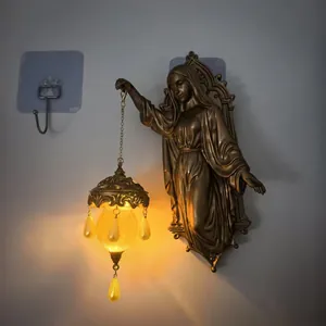 Antique bronze wall lamp featuring a religious figure holding a glowing lantern detail