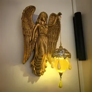 Detail of vintage golden angel wall lamp with hanging warm-light decorative lantern
