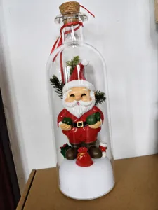 Detailed view of the Christmas Santa Claus figurine inside a glass bottle ornament