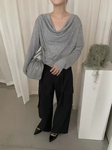 Détail rapproché d'un haut gris à col bénitier avec un effet drapé élégant