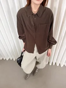 Camicia retrò in velluto a coste marrone e pantaloni beige larghi.