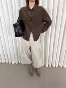 Dettaglio di una camicia retrò in velluto a coste marrone scuro per l'inizio autunno
