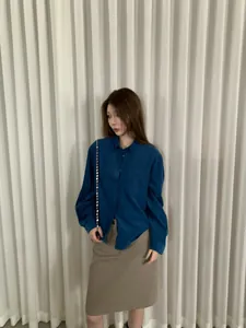 Donna elegante che indossa una camicia di velluto a coste blu a maniche lunghe, look autunno