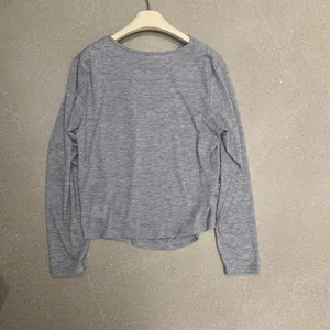 Vue arrière d'un haut à manches longues gris uni minimaliste montrant la texture
