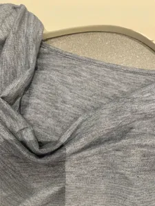 Détail d'un haut gris à col bénitier montrant la texture douce du tissu.