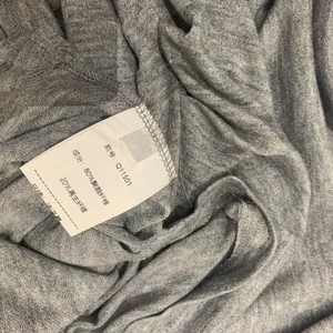 Vue détaillée de l'étiquette de lavage et de la texture du tissu en maille grise