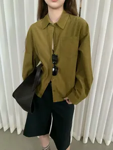 Modella indossa una camicia in velluto a coste retrò verde oliva con vestibilità casual
