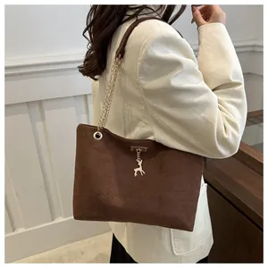 Vista dettagliata di una borsa tote in pelle scamosciata marrone con catena oro e ciondolo