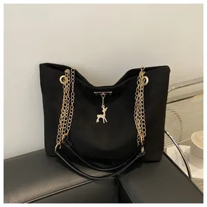 Borsa shopper in camoscio nero con spalline a catena dorata e ciondolo a forma di cervo.