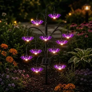 Solar Halloween stake light with purple glowing bats in a night garden setting.
