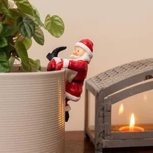 Detailansicht einer Weihnachtsmann-Figur aus Harz, die an einem Blumentopf hängt