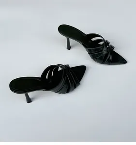 Vista detallada de sandalias negras retro de tacón alto con tiras cruzadas elegantes