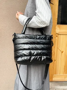 Bolso tote acolchado negro para mujer con gran capacidad y correa de hombro ajustable.