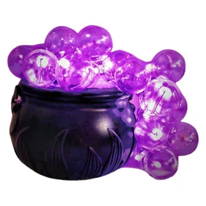 Macro view of a black Halloween witch cauldron with glowing purple bubble lights