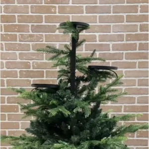 Detail of a black triple-tier iron candle holder mounted on a green Christmas tree topper.