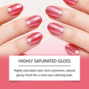 Close-up of red glitter manicured nails featuring pearl accents and high saturated gloss finish