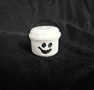 Vista dettagliata del mini secchiello di Halloween bianco con faccina nera e manico