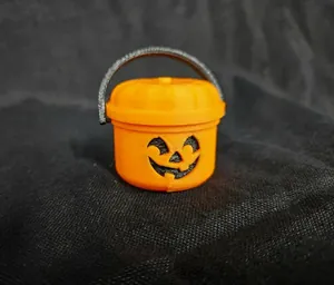 Dettaglio ravvicinato di un secchiello a zucca arancione in miniatura stampato in 3D Halloween