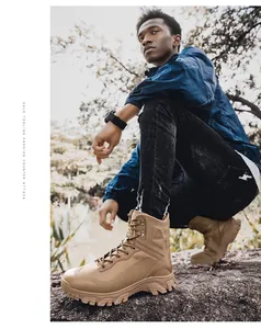Close-up of tan mid-top tactical boots on a rugged outdoor rock surface